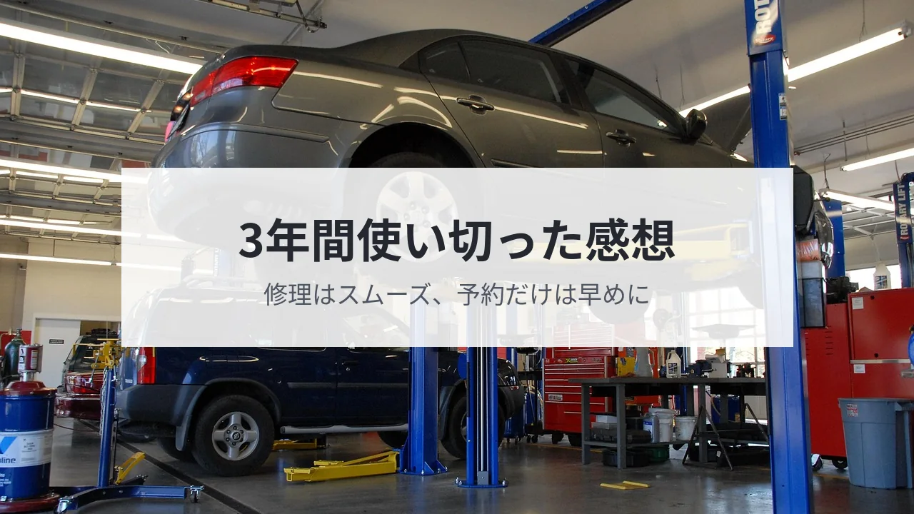 リフトで持ち上げて整備中の車がある整備工場の写真