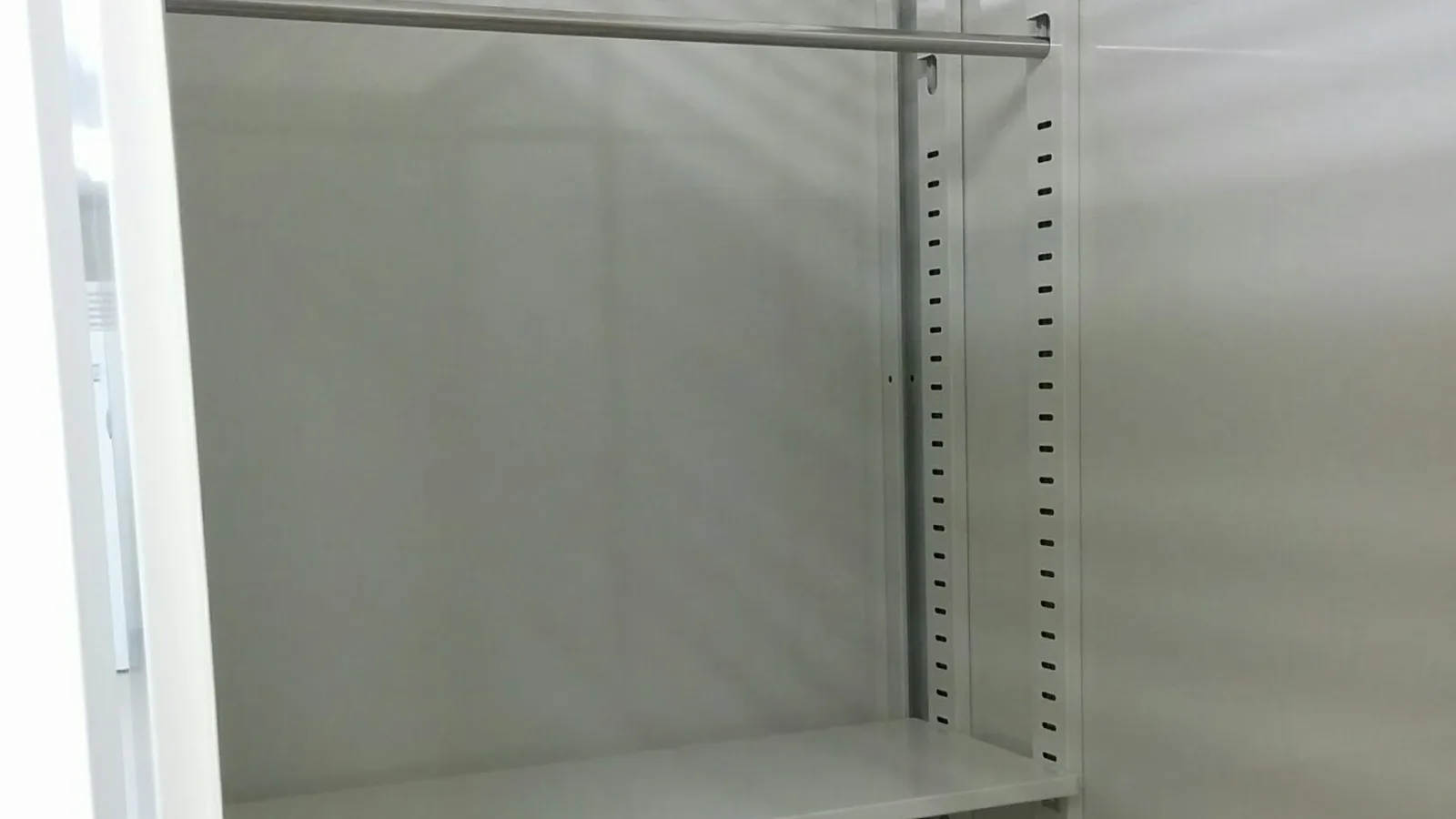 棚とハンガーパイプが付いた屋内型トランクルームの区画の中